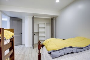 Ein Schlafzimmer mit Bett, Kleiderschrank und einer Tür zu einem anderen Raum.