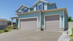 A two-story house with a garage, a covered porch, and a well-maintained lawn. - Stay Near Salt Lake, Hill AFB & Snowbasin! (Layton)