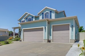 Ein zweistöckiges Haus mit Garage, überdachter Veranda und gepflegtem Rasen.