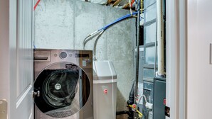 A laundry room with a washing machine, a dryer, and various plumbing pipes. - Stay Near Salt Lake, Hill AFB & Snowbasin! (Layton)
