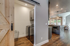 A modern kitchen with built-in appliances, a wooden floor, and a view to the outdoor area. - Walk to Autzen Stadium: Eugene Getaway w/ Yard (Eugene)
