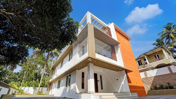Un bâtiment moderne à deux étages, doté d’un toit plat, de grandes fenêtres et d’un balcon.