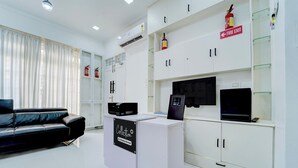 A modern office space with a reception desk, a black leather sofa, and white cabinets. - Super Collection O Kulathoor Technopark (Thiruvananthapuram)