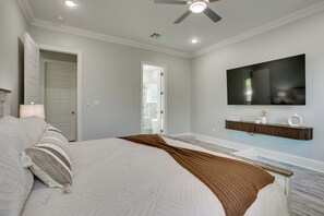 A bedroom with a bed, a television mounted on the wall, and a bathroom visible through an open door. - 4 Mi to New Orleans! Extended Stay in Arabi (Arabi)