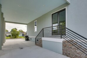 A covered outdoor area with a concrete floor, a brick column, and a metal staircase with a handrail. - 4 Mi to New Orleans! Extended Stay in Arabi (Arabi)