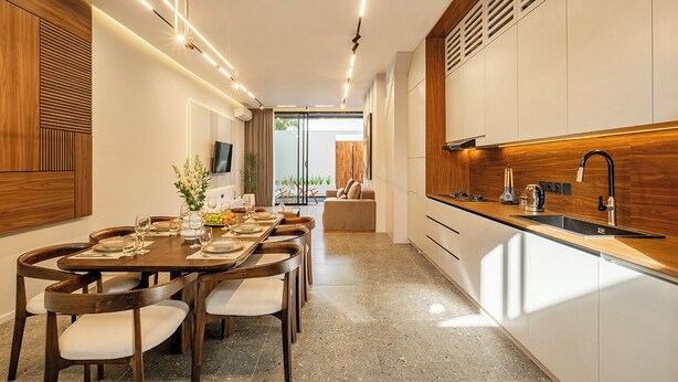 A modern kitchen with a dining area, wooden cabinetry, and a built-in TV. - Elegant 2BR Private Pool Villa Umalas (Badung)