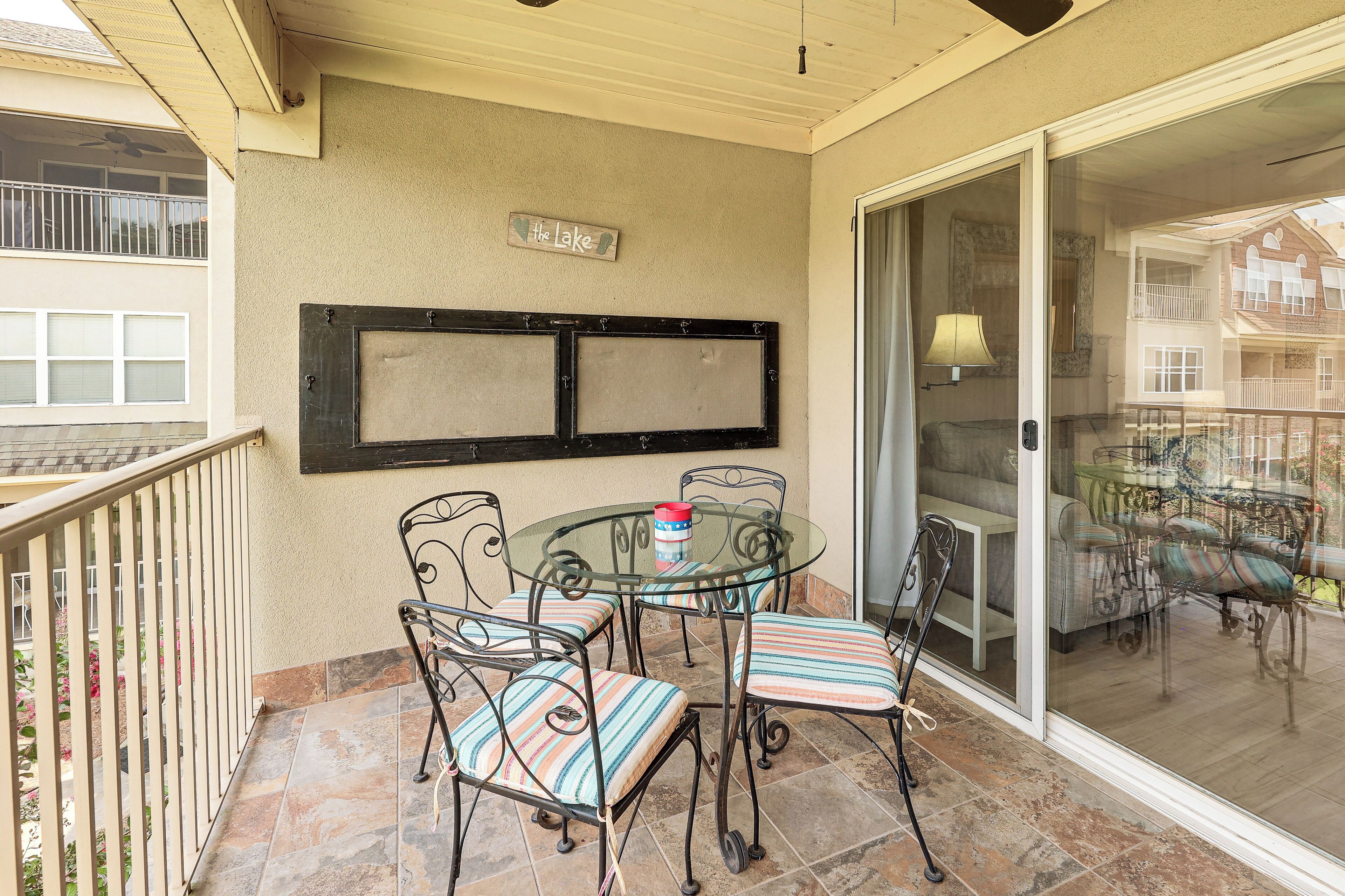 Un balcon avec une porte vitrée, une table avec des chaises et une pancarte sur laquelle on peut lire : « Le Lac ».