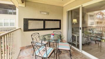 A balcony with a glass door, a table with chairs, and a sign that reads 'The Lake'.