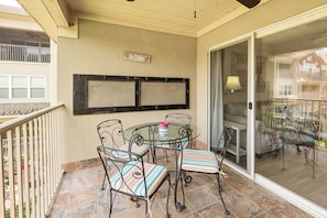 A balcony with a glass door, a table with chairs, and a sign that reads 'The Lake'.