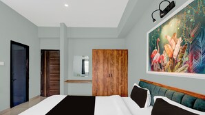 A modern hotel room with a large bed, a wooden wardrobe, a mirror, and a vibrant floral painting on the wall. - Super Collection O Udaipur City (Udaipur)