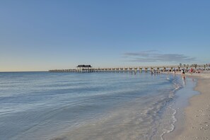 A pier extending into calm waters with people walking along it. - Walk to Beach! Old Naples Condo w/ Pool Access (Naples)