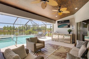 A spacious indoor area with a pool, outdoor seating, and a kitchen area. - Boat Dock & Outdoor Kitchen! Port Charlotte Escape (Port Charlotte)