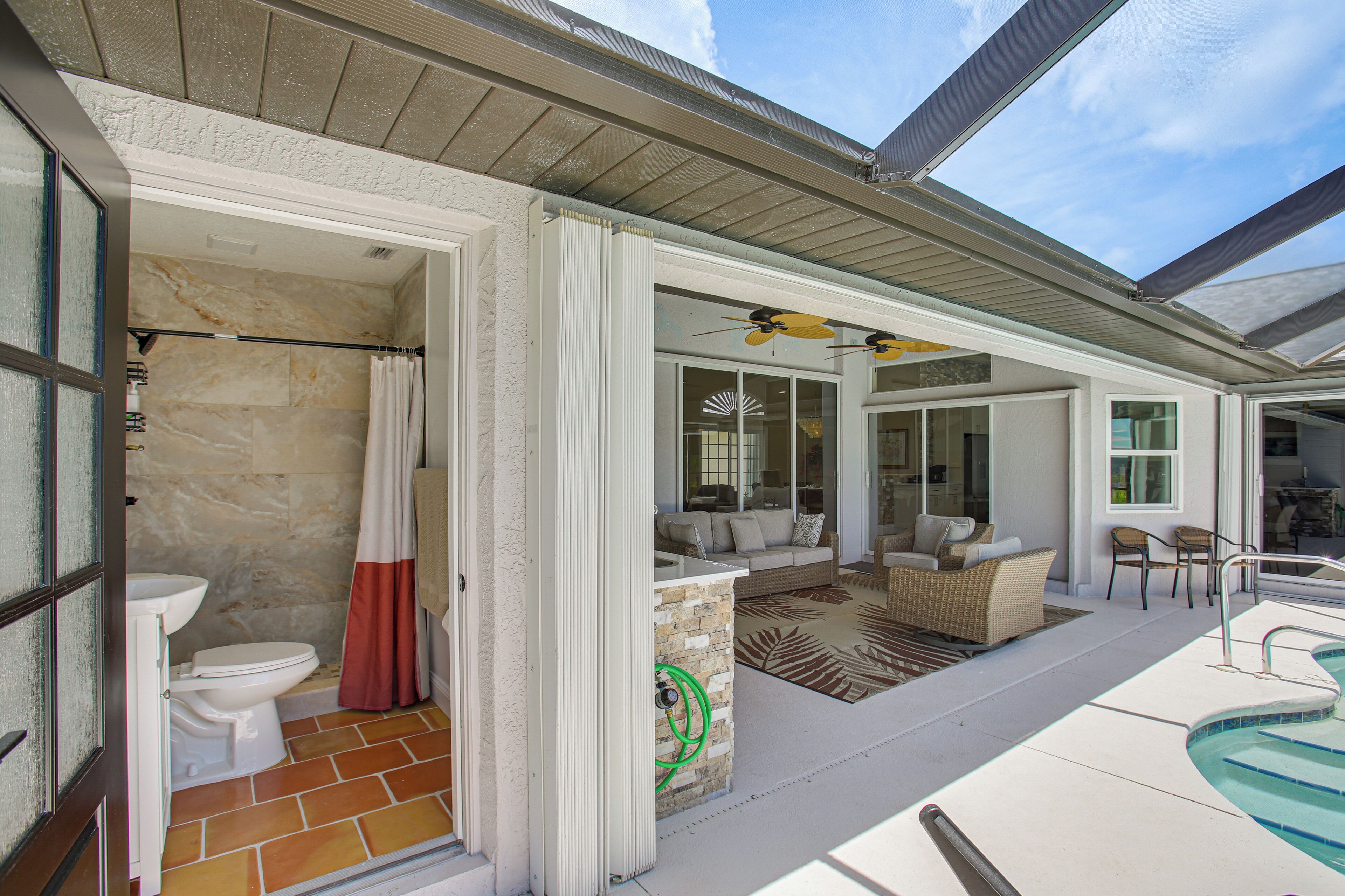 Una propiedad residencial con baño, una sala de estar con sofá y sillones, y una piscina.