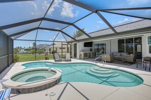 Ein überdachter Pool im Freien mit Whirlpool, Liegestühlen und einer Terrasse mit Gartenmöbeln.