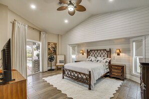 A bedroom with a large bed, a ceiling fan, and a view of the outdoors. - Boat Dock & Outdoor Kitchen! Port Charlotte Escape (Port Charlotte)