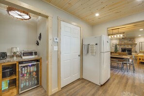A kitchen with a refrigerator, microwave, and a glass-fronted beverage cooler. - Waterfront Stay w/ Dock & Views on Minong Flowage (Minong)