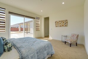 A bedroom with a bed, a chair, a small table, and a painting on the wall. - Private Yard & Patio! Modern Manteca Gem (Manteca)