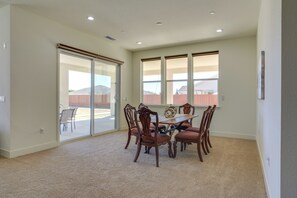 A dining area with a table and chairs, large windows, and a view of the outside. - Private Yard & Patio! Modern Manteca Gem (Manteca)