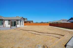 A residential backyard with a house, a wooden fence, and a clear sky. - Private Yard & Patio! Modern Manteca Gem (Manteca)