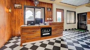 A reception desk with a wooden finish, a black and white checkered floor, and a ceiling with recessed lighting. - Collection O RTO Office Udaipur (Udaipur)