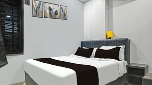A bedroom with a bed, a nightstand, a lamp, and three wall art pieces. - Super Collection O Mahakal (Ujjain)