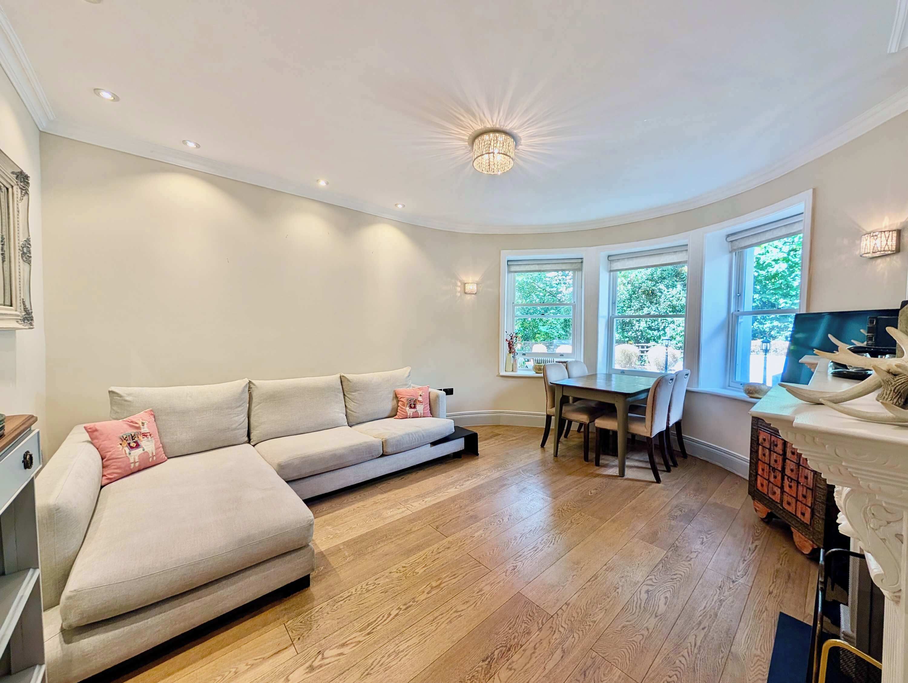 Ein modernes Wohnzimmer mit Sofa, Esstisch und Stühlen.