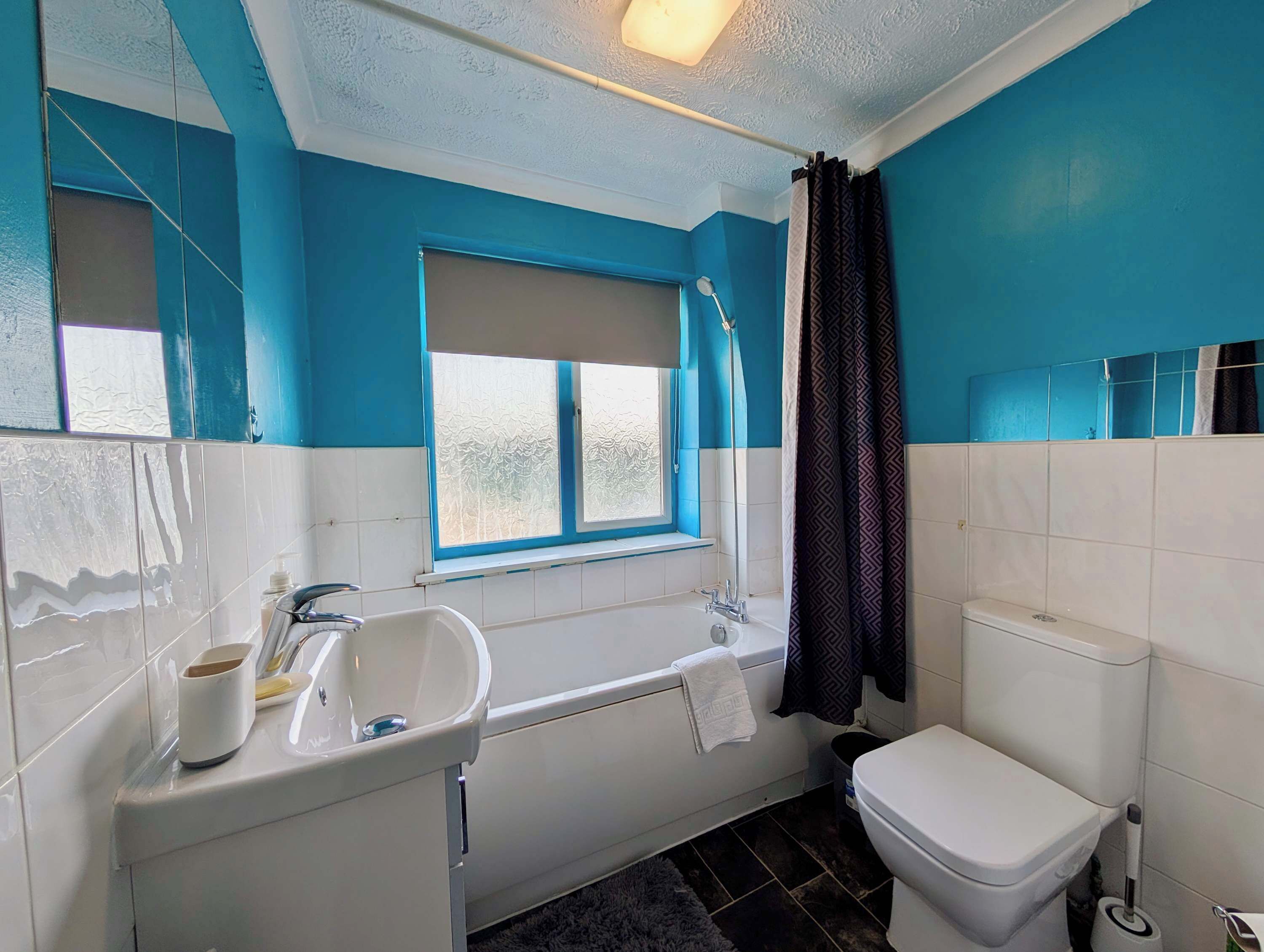 Een badkamer met bad, toilet en wastafel.
