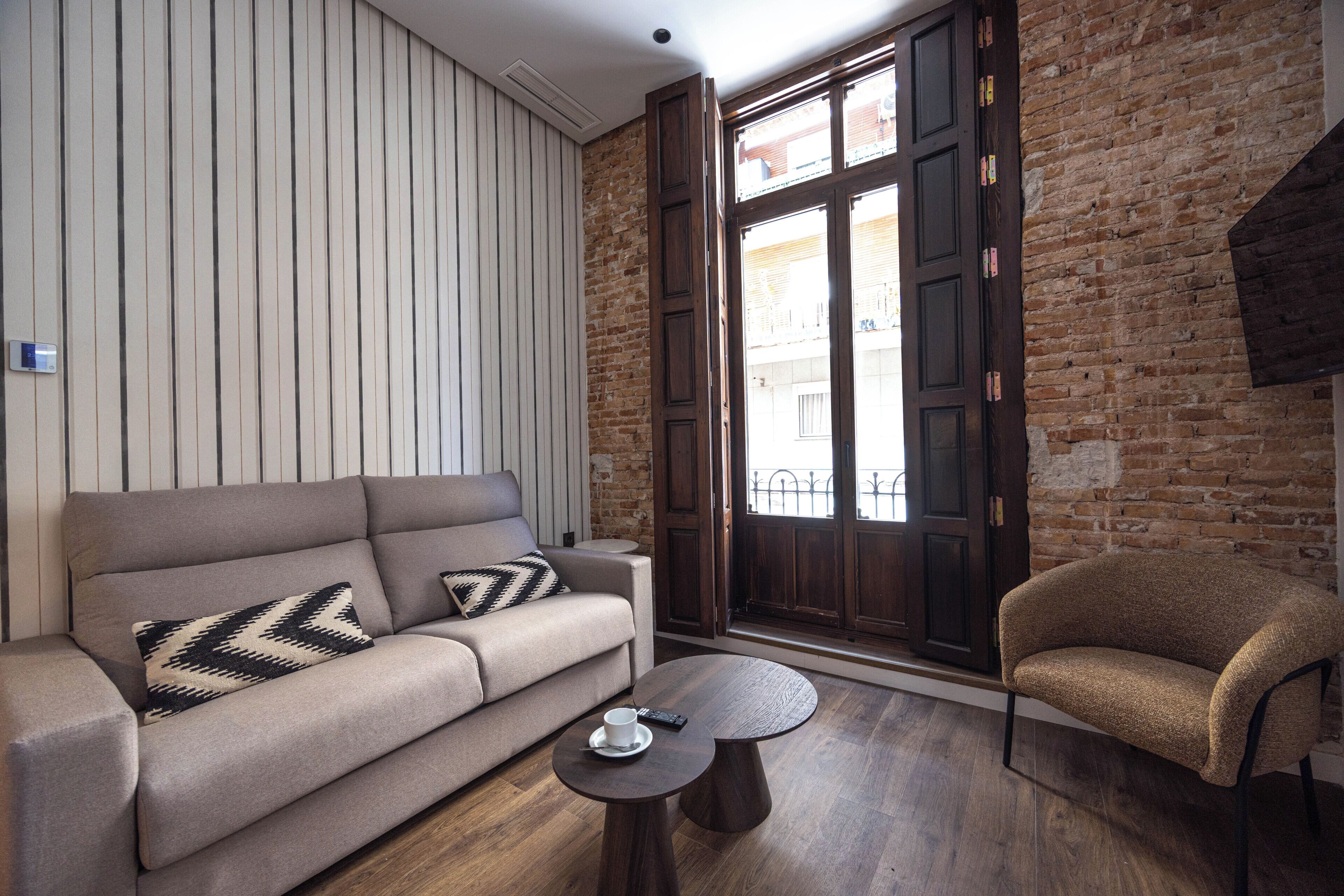 A modern living room with a sofa, a round coffee table, and a chair.