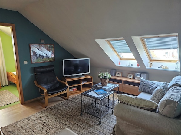 A modern living room with a television, seating area, and skylights. - "Lotseneck" Apartment - A Dream Location in Timmendorf Strand (Insel Poel / OT Timmendorf Strand)