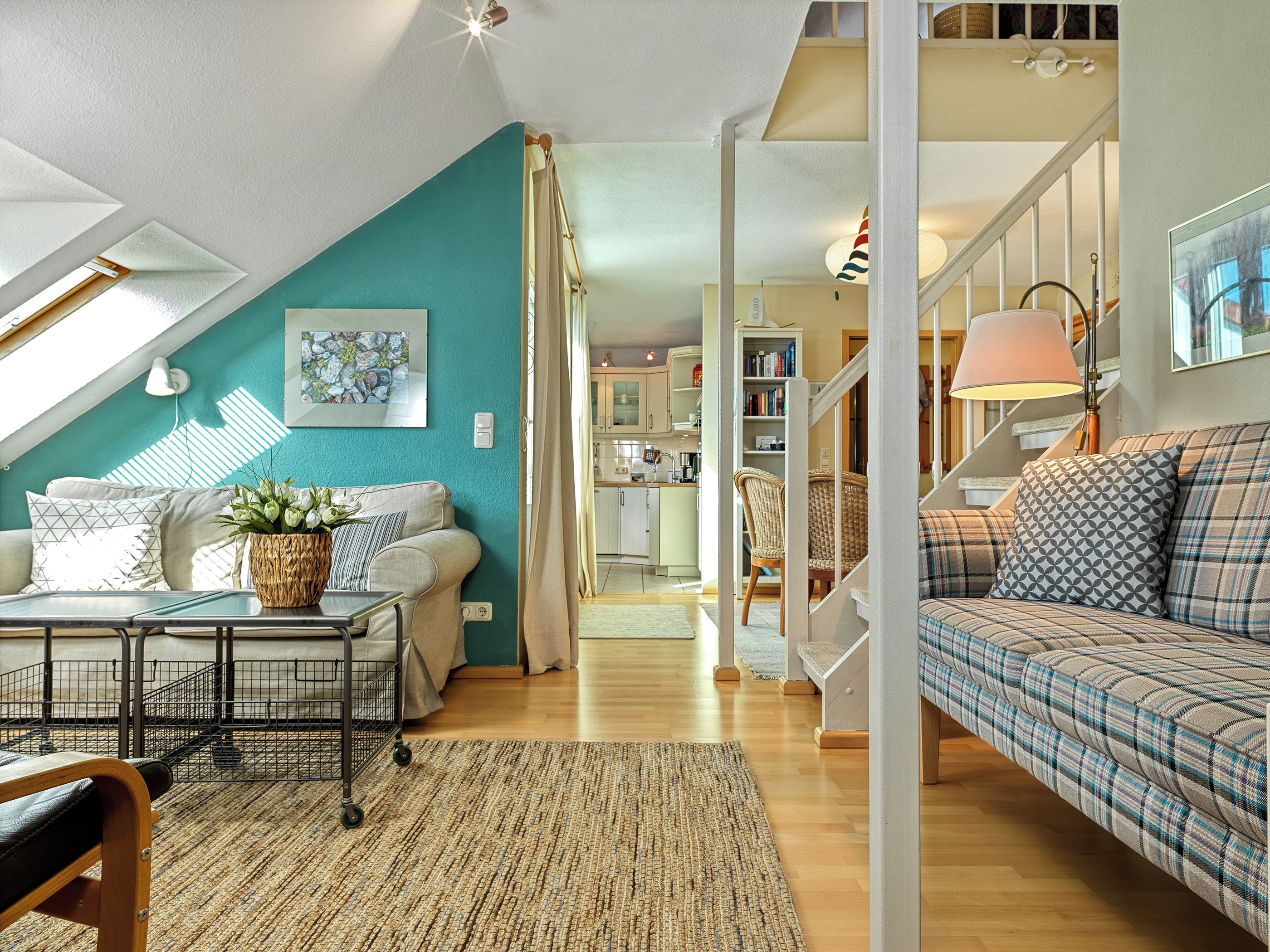 A cozy living room with a sofa, a coffee table, and a dining area with a table and chairs.