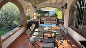 An outdoor patio with a dining table, chairs, and a sofa.