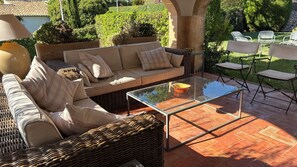 An outdoor seating area with a wicker sofa, cushions, and a glass-top table. - A home with a Mediterranean feel in one of Jávea's most exclusive residential developments (Jávea)