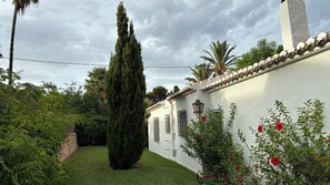 A white building with a tiled roof, surrounded by greenery and a tall tree. - A home with a Mediterranean feel in one of Jávea's most exclusive residential developments (Jávea)