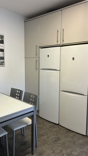 A compact kitchen with a table and chairs, a refrigerator, and cabinets. - A home with a Mediterranean feel in one of Jávea's most exclusive residential developments (Jávea)