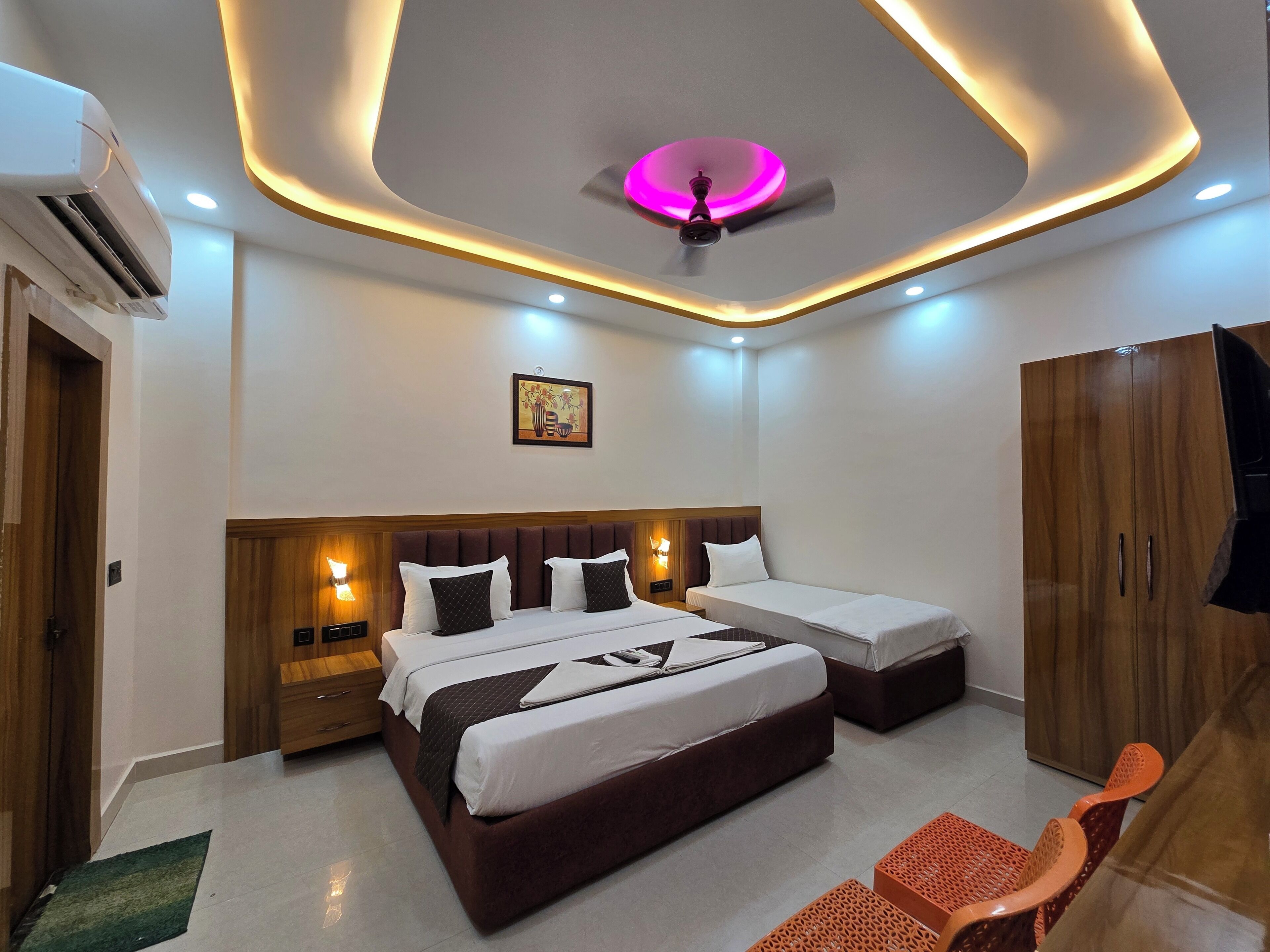A hotel room with a bed, bedside tables, a wardrobe, and a ceiling light fixture.