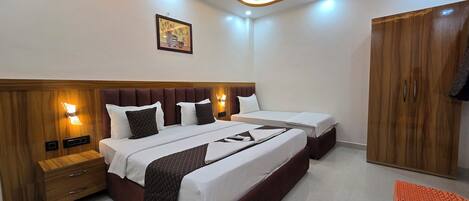 A hotel room with a large bed, bedside tables, a wardrobe, and a ceiling fan.