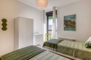 Quarto com duas camas, um guarda-roupa e um quadro na parede.