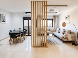 Una sala de estar moderna con un sofá, una mesa de centro y un comedor con sillas y una mesa.