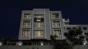 A multi-story hotel with a modern facade, large windows, and a sign indicating it is a company-serviced collection. - Collection O Shirdi (Shirdi)