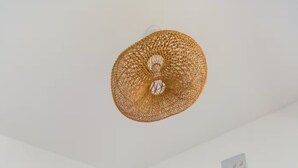 Un dormitorio con una cama, una mesita de noche, una lámpara y una pared decorada con cuadros.