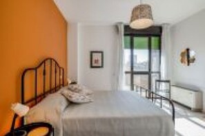 Ein Schlafzimmer mit Bett, Fenster und Tür.