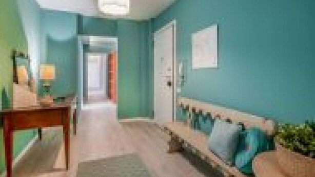 A hallway with a wooden bench, a table, and a door. - GuestHost - Family & Friends House - Spring Room (Padua)