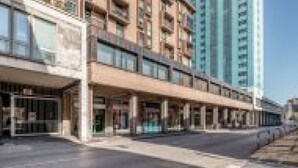 A multi-story hotel with a ground-level retail space and a parking area. - GuestHost - Family & Friends House - Spring Room (Padua)