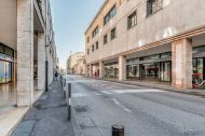 Eine Straße mit modernen Gebäuden, blauem Himmel und einem Bürgersteig.