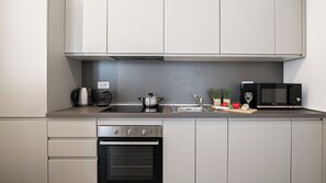 Een moderne keuken met roestvrijstalen apparatuur, een inbouwoven en een magnetron.