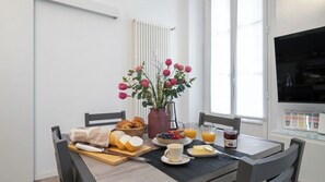 A breakfast table with bread, fruit, and a vase of flowers. - Italianway Comfort - Cellini 1 (Milan)