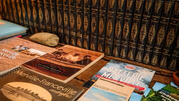 Een verzameling boeken, waaronder 'La Côte Fleurie' en 'Batterie Musee Normandie,' op een houten oppervlak.