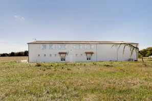 Un bâtiment d’un seul étage, doté d’un toit plat, de nombreuses fenêtres avec volets et d’un petit porche.