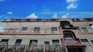 A multi-story building with balconies and a sign indicating a company-serviced collection.