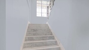 A staircase with a handrail and a window at the top.